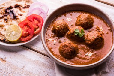 Kızartma tavasında taze pişirilmiş baharatlı patates körisi mi yoksa tandır roti veya naan veya Hint ekmeği veya chapati ve yeşil salata ile servis edilen sıcak ve baharatlı Dum aloo mu?