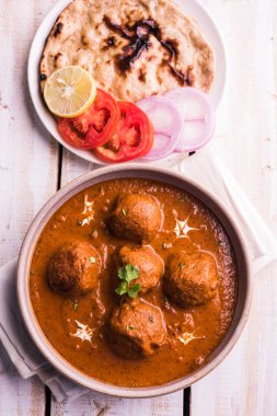 Kızartma tavasında taze pişirilmiş baharatlı patates körisi mi yoksa tandır roti veya naan veya Hint ekmeği veya chapati ve yeşil salata ile servis edilen sıcak ve baharatlı Dum aloo mu?