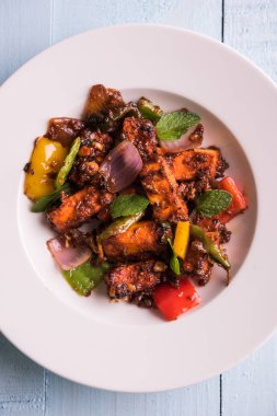 Kırmızı biber ya da baharatlı süzme peynir, kapsiyum ve soğanla servis edilir, favori Hint başlangıç menüsü, seçici odaklanma.