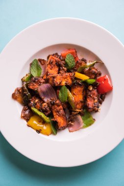 Kırmızı biber ya da baharatlı süzme peynir, kapsiyum ve soğanla servis edilir, favori Hint başlangıç menüsü, seçici odaklanma.