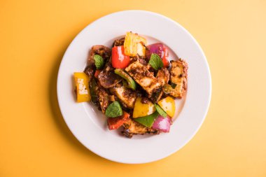 Kırmızı biber ya da baharatlı süzme peynir, kapsiyum ve soğanla servis edilir, favori Hint başlangıç menüsü, seçici odaklanma.