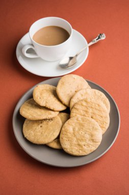 Baharatlı kızarmış mathri veya Hint bir aperatif olan mathari bir bardak çay, seçici odak ile servis