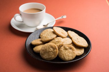Baharatlı kızarmış mathri veya Hint bir aperatif olan mathari bir bardak çay, seçici odak ile servis