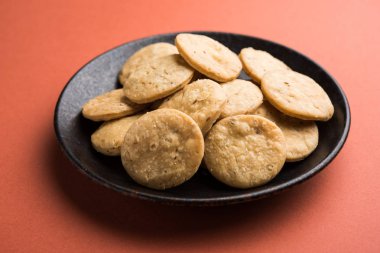 Baharatlı kızarmış mathri veya Hint bir aperatif olan mathari bir bardak çay, seçici odak ile servis