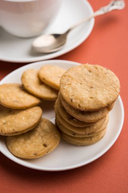 Baharatlı kızarmış mathri veya Hint bir aperatif olan mathari bir bardak çay, seçici odak ile servis