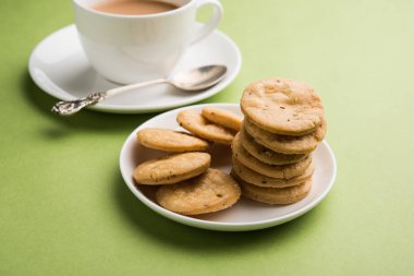 Baharatlı kızarmış mathri veya Hint bir aperatif olan mathari bir bardak çay, seçici odak ile servis