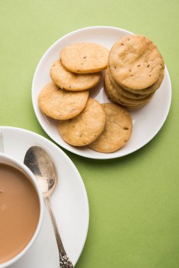 Baharatlı kızarmış mathri veya Hint bir aperatif olan mathari bir bardak çay, seçici odak ile servis