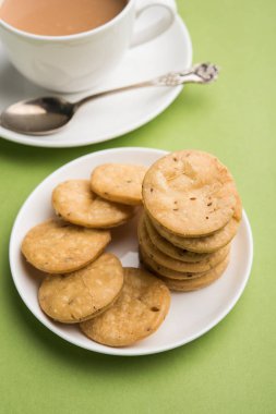 Baharatlı kızarmış mathri veya Hint bir aperatif olan mathari bir bardak çay, seçici odak ile servis