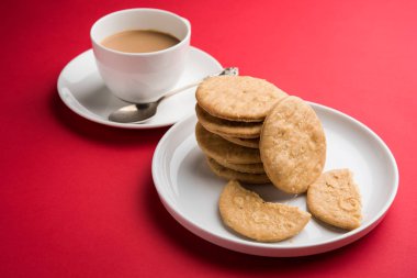 Baharatlı kızarmış mathri veya Hint bir aperatif olan mathari bir bardak çay, seçici odak ile servis