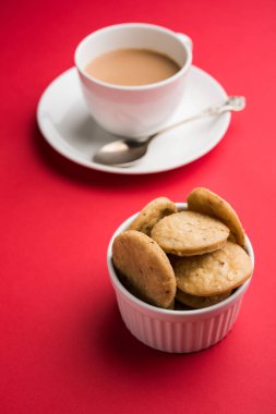 Baharatlı kızarmış mathri veya Hint bir aperatif olan mathari bir bardak çay, seçici odak ile servis