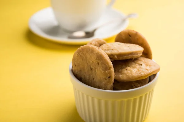 Mathri o mathari fritti piccanti che è uno spuntino indiano servito con una tazza di tè, fuoco selettivo — Foto Stock