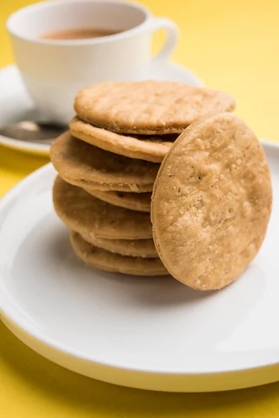 Mathri o mathari fritti piccanti che è uno spuntino indiano servito con una tazza di tè, fuoco selettivo — Foto Stock