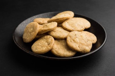 Baharatlı kızarmış mathri veya Hint bir aperatif olan mathari bir bardak çay, seçici odak ile servis