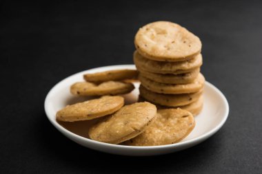 Baharatlı kızarmış mathri veya Hint bir aperatif olan mathari bir bardak çay, seçici odak ile servis