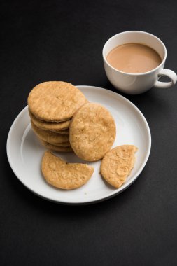 Baharatlı kızarmış mathri veya Hint bir aperatif olan mathari bir bardak çay, seçici odak ile servis