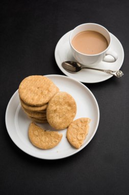 Baharatlı kızarmış mathri veya Hint bir aperatif olan mathari bir bardak çay, seçici odak ile servis