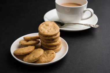 Baharatlı kızarmış mathri veya Hint bir aperatif olan mathari bir bardak çay, seçici odak ile servis