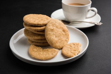 Baharatlı kızarmış mathri veya Hint bir aperatif olan mathari bir bardak çay, seçici odak ile servis