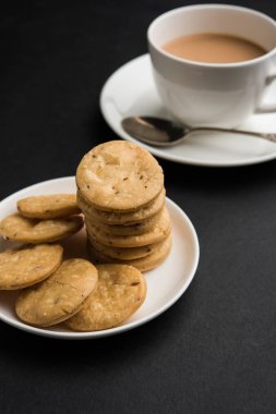 Baharatlı kızarmış mathri veya Hint bir aperatif olan mathari bir bardak çay, seçici odak ile servis