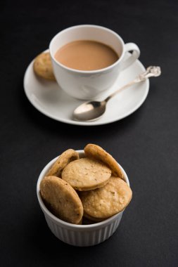Baharatlı kızarmış mathri veya Hint bir aperatif olan mathari bir bardak çay, seçici odak ile servis