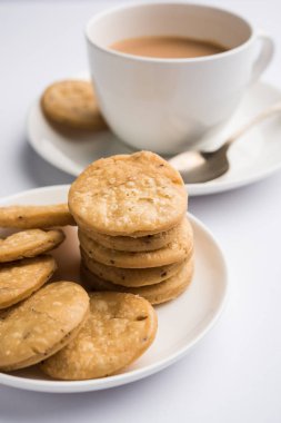 Baharatlı kızarmış mathri veya Hint bir aperatif olan mathari bir bardak çay, seçici odak ile servis