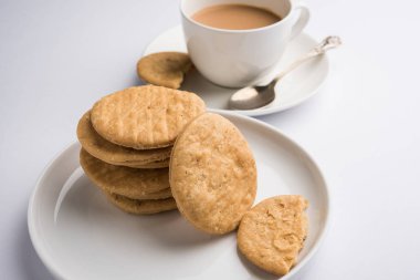Baharatlı kızarmış mathri veya Hint bir aperatif olan mathari bir bardak çay, seçici odak ile servis