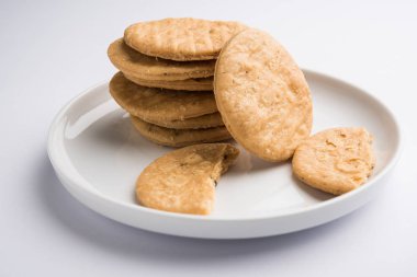 Baharatlı kızarmış mathri veya Hint bir aperatif olan mathari bir bardak çay, seçici odak ile servis