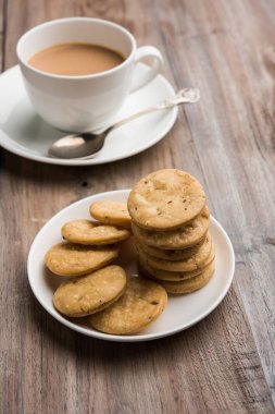 Baharatlı kızarmış mathri veya Hint bir aperatif olan mathari bir bardak çay, seçici odak ile servis