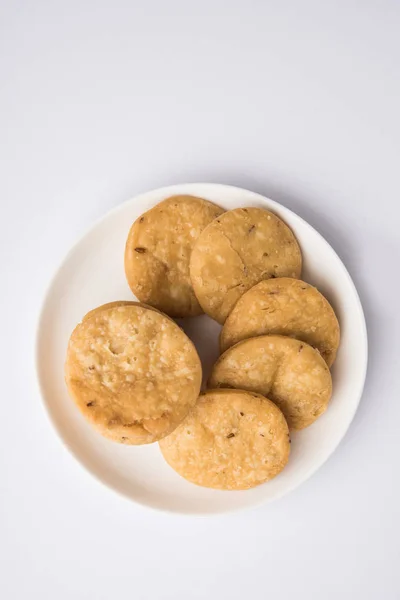 Kruidige gebakken mathri of mathari is een Indiase snack geserveerd met een kopje thee, selectieve aandacht — Stockfoto