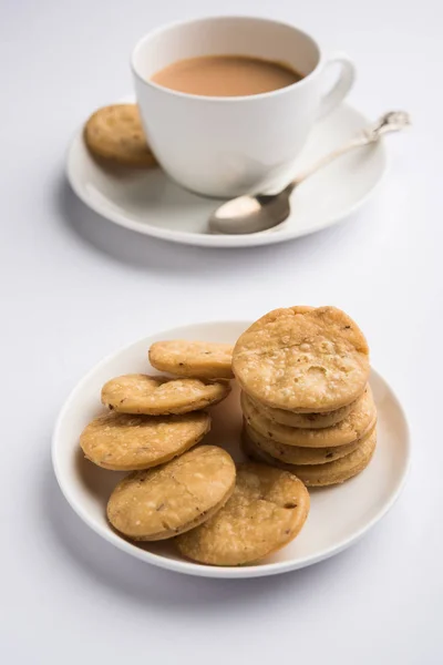 Würzig gebratener Mathri oder Mathari, ein indischer Snack, der mit einer Tasse Tee serviert wird, selektiver Fokus — Stockfoto