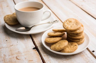 Baharatlı kızarmış mathri veya Hint bir aperatif olan mathari bir bardak çay, seçici odak ile servis
