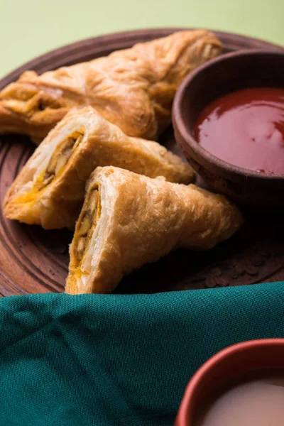 stuffed vegetable or veg puff or puf or samosa, famous indian snack menu, served with hot tea, selective focus