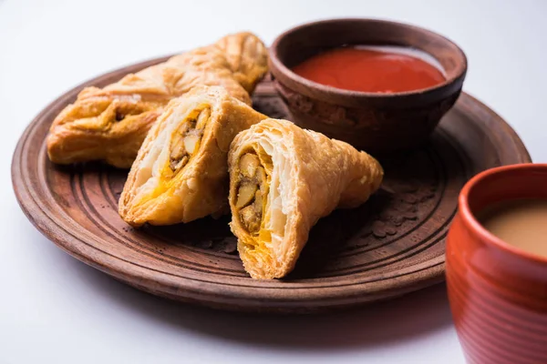 Stuffed vegetable or veg puff or puf or samosa, famous indian snack menu, served with hot tea, selective focus — Stock Photo, Image