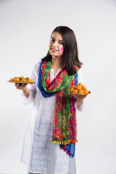 印度漂亮的小女孩拿着满满一盘甜甜的邦迪 拉杜或古吉娅的盘子参加一个叫做 Holi 的印度节庆 与白人背景隔离 有选择性地聚焦 — 图库照片