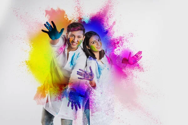 young indian couple in traditional wear with faces painted  celebrating Holi, isolated over white background