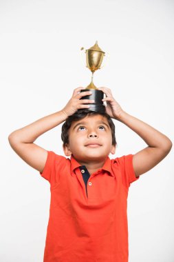 bir kazanan Kupası ya da kupa beyaz arka plan üzerinde tutan Hintli çocuk