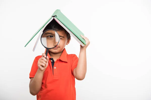 Bonito indiana menino segurando livro sobre cabeça como telhado, isolado sobre fundo branco — Fotografia de Stock