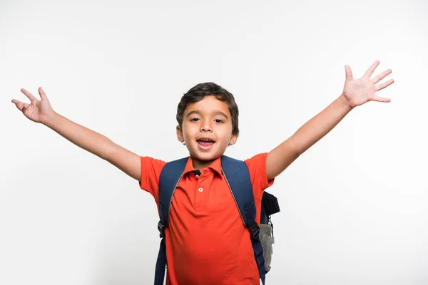 Indian cute kid or boy leaving or going to school with small school bag, isolated over white background — Stock Photo, Image