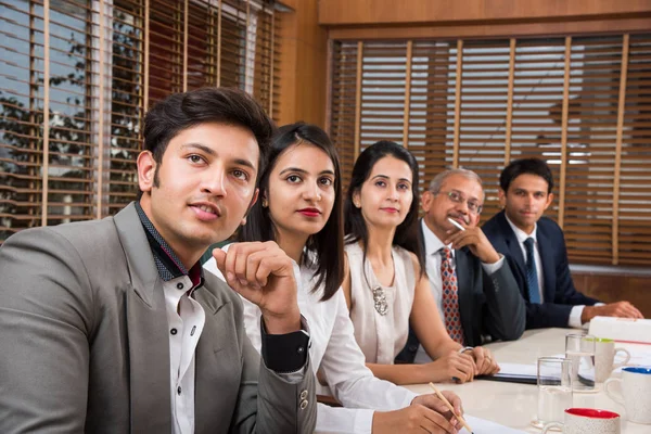 Group Of Indian Businesspeople In Video Conference or at presentation or listening to a sales speech At Business Meeting, with a miniature indian flag post over table