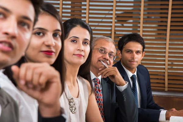 Group Of Indian Businesspeople In Video Conference or at presentation or listening to a sales speech At Business Meeting, with a miniature indian flag post over table