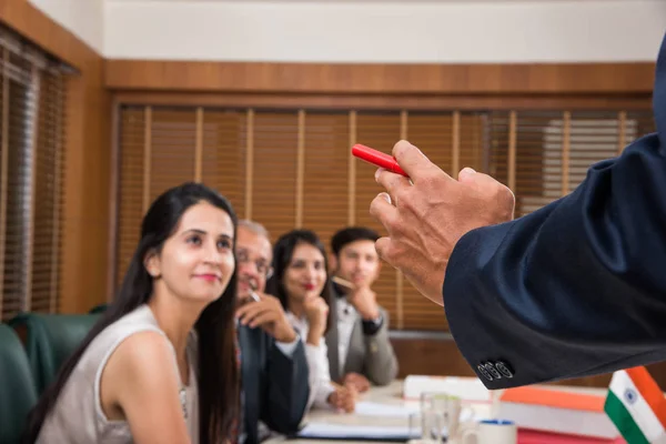 Group Of Indian Businesspeople In Video Conference or at presentation or listening to a sales speech At Business Meeting, with a miniature indian flag post over table