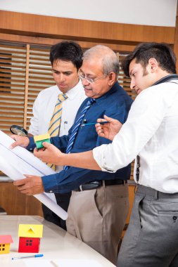 Hint ekibi bina modeli ve planı, ev, seçici odak ile tartışırken konut projesi mimar