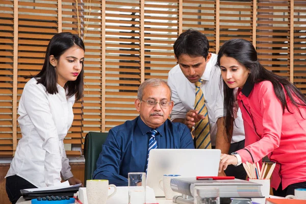 Yeni plan memnun. Gençlerin Grup 4-5 Hint neşeli ve gülümseme yaslanmış ofiste tabloda için süre ile laptop arıyorum bir deneyimli iş adamı — Stok fotoğraf
