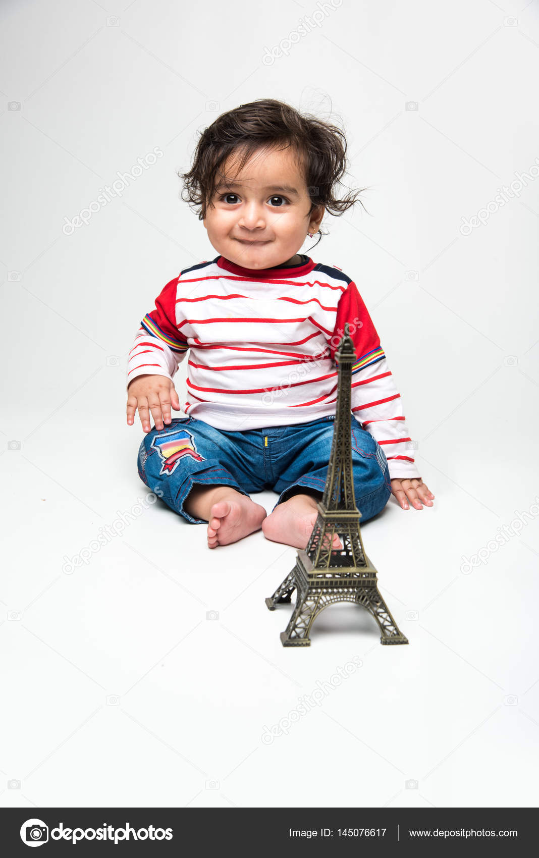 Indian Baby Boy With Long Hair Sitting Over White Background With Toy Model Or Replica Of Eiffel Tower Stock Photo C Stockimagefactory Com 145076617