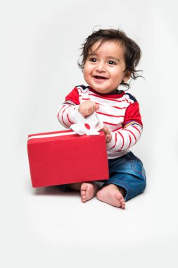 Beyaz arka plan üzerinde izole Hint bebek çocuk veya bebek holding kırmızı hediye kutusu,