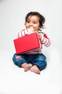 Beyaz arka plan üzerinde izole Hint bebek çocuk veya bebek holding kırmızı hediye kutusu,