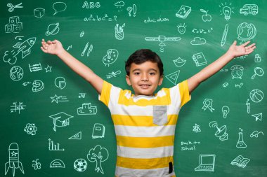 Hint okul üzerinde yeşil kara tahta veya tebeşir kurulu arka plan, Hintli çocuk üzerinde yeşil kara tahta arka plan ile karalamalar - okuldaki geri okul kavramı ayakta el uzatılmış poz evlat