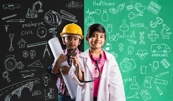 Çocuklar ve eğitim kavramı - küçük Hintli erkek ve kız sarı kask ile mühendisler fancy dress ve doktor kostüm stetoskop, yeşil tebeşir kurulu önünde poz mühendis ya da doktor olmak istiyorum