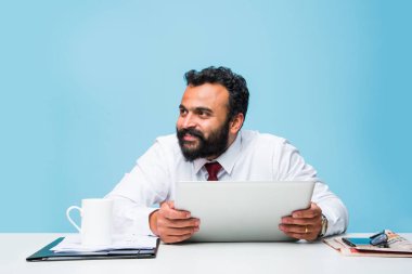 Sekme veya tablet pc ofis masaları, dokunmatik yüzey tutan Asya iş kişi otururken mutlu bakışla tutan Hintli işadamı sakallı