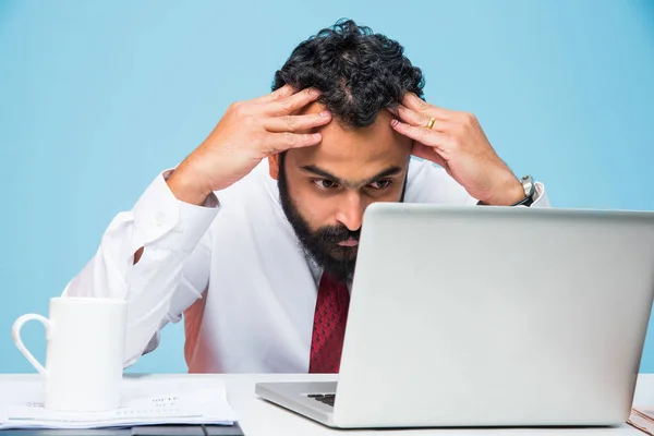 Frustrerad indisk ung affärsman med skägg visar sorgligt uttryck i kontoret på datorbord — Stockfoto